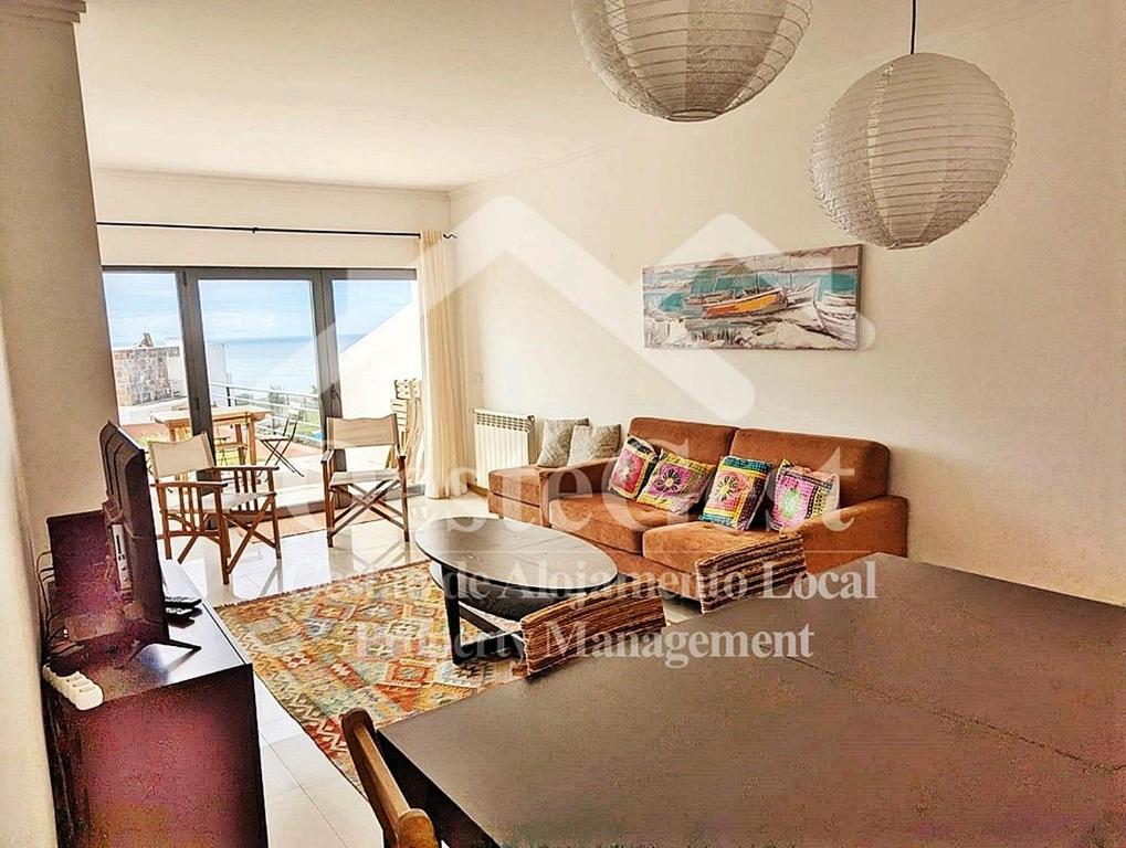 een woonkamer met een bank en een tafel bij The Lookout in Areia Branca