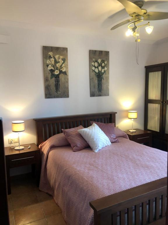 a bedroom with a bed with two lamps and two pictures on the wall at PLAYA VERDE LUXURY in Ayamonte