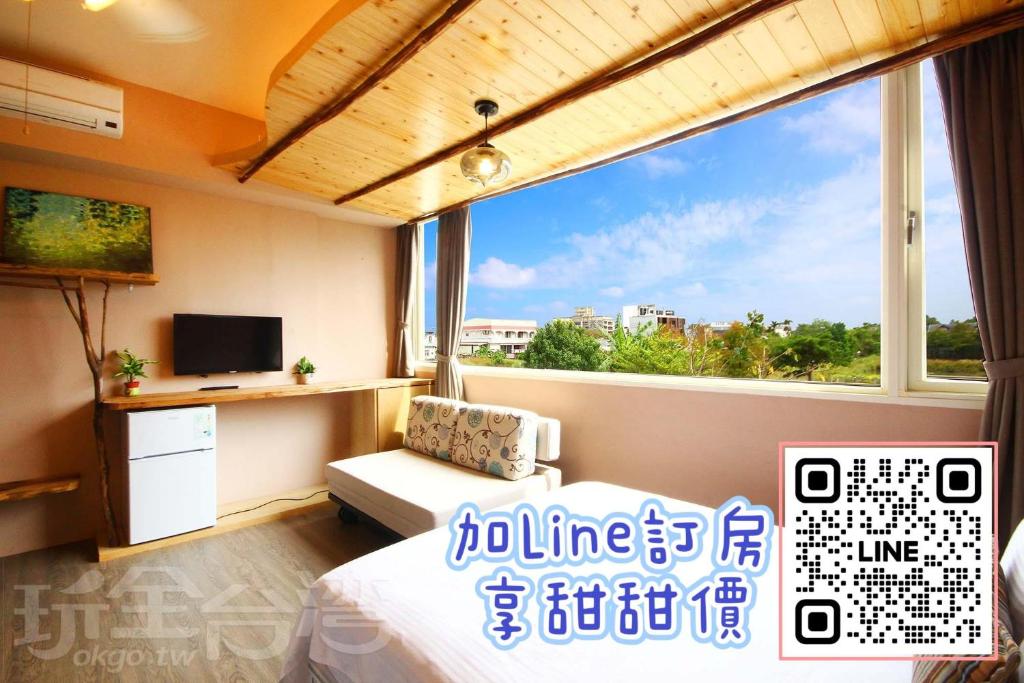 um quarto com uma cama e uma grande janela em 田中歐寒集b&b em Dongshan