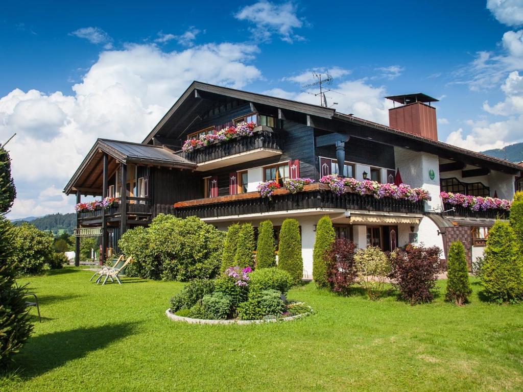 a house with flowers in front of it at Allgäuer Landhaus in Fischen