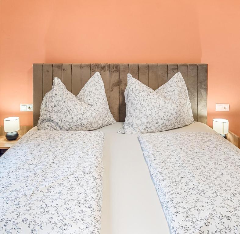 a bedroom with two beds with white sheets and pillows at Hallstatt Lakeside Top 1 in Hallstatt