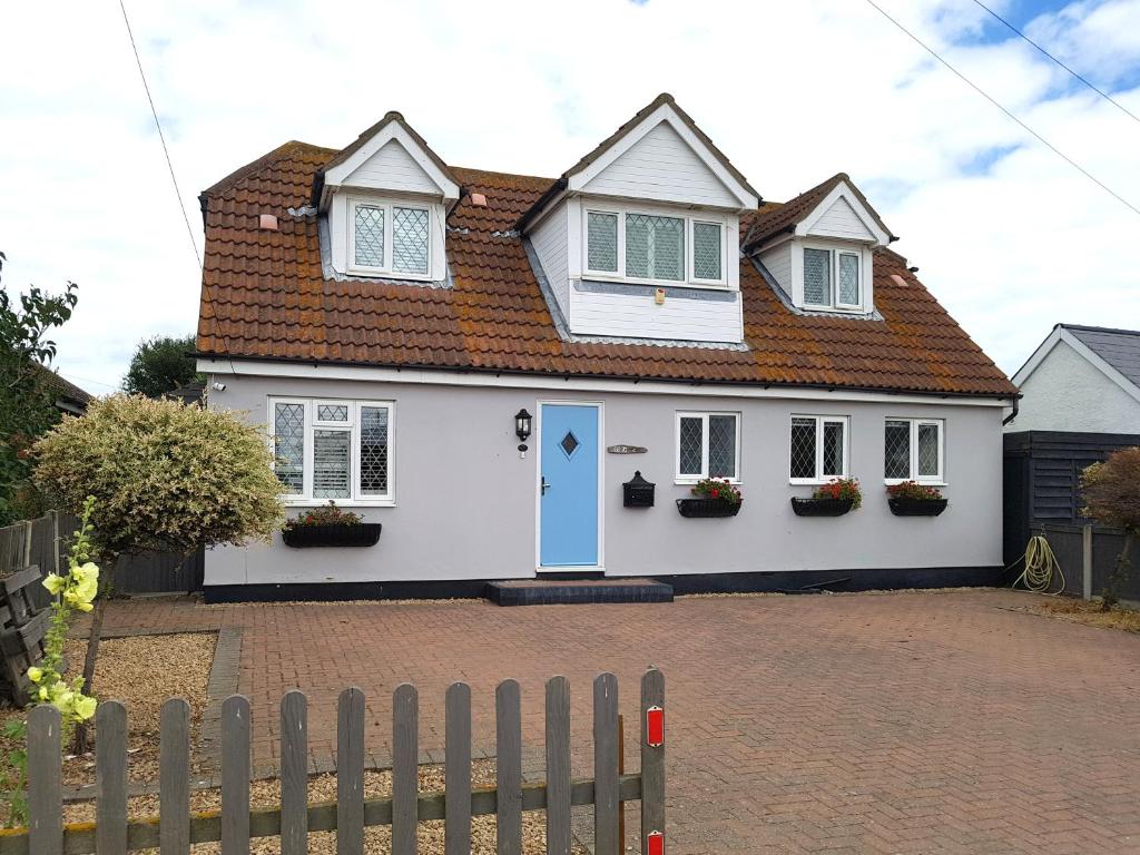 une maison blanche avec un toit rouge dans l'établissement 3-Bedroom Family Home. Just 5 Mins From The Beach!, à Kent