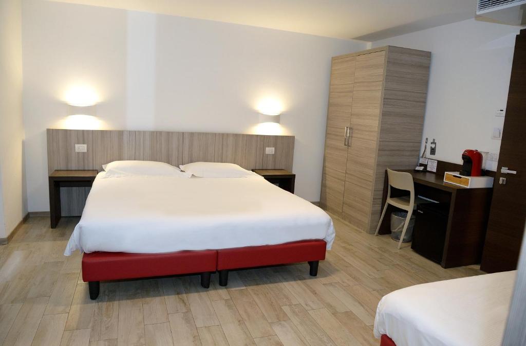 ein Hotelzimmer mit einem großen Bett und einem Schreibtisch in der Unterkunft Break Affittacamere in San Vito al Tagliamento