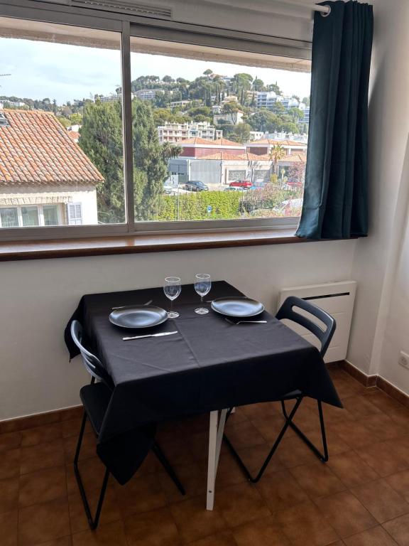 une table noire avec deux lunettes devant une fenêtre dans l'établissement STUDIO CASSIS, à Cassis