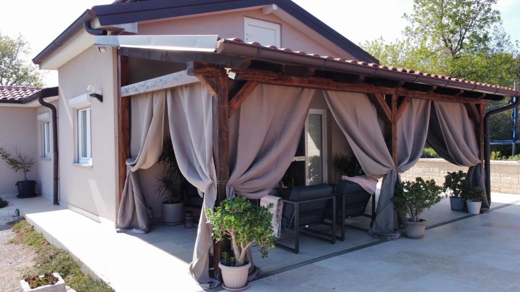 a patio with awning and curtains on a house at Vacation house ''CASA TERRA'' in Poreč