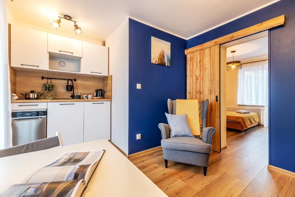 a kitchen and living room with blue walls at KEJB Chałupy in Chałupy