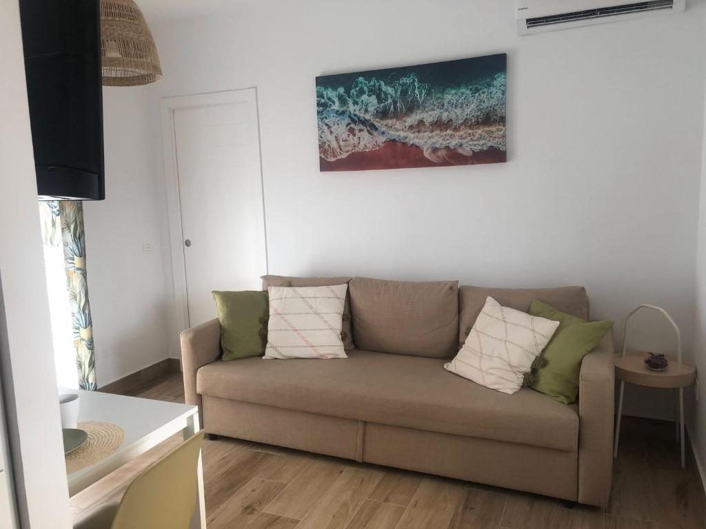 a living room with a couch and a painting on the wall at Apartamentos MareaBeach in Torremolinos