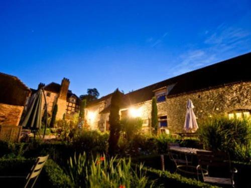 a building with an outdoor patio with tables and umbrellas at Old Downton Lodge in Downton