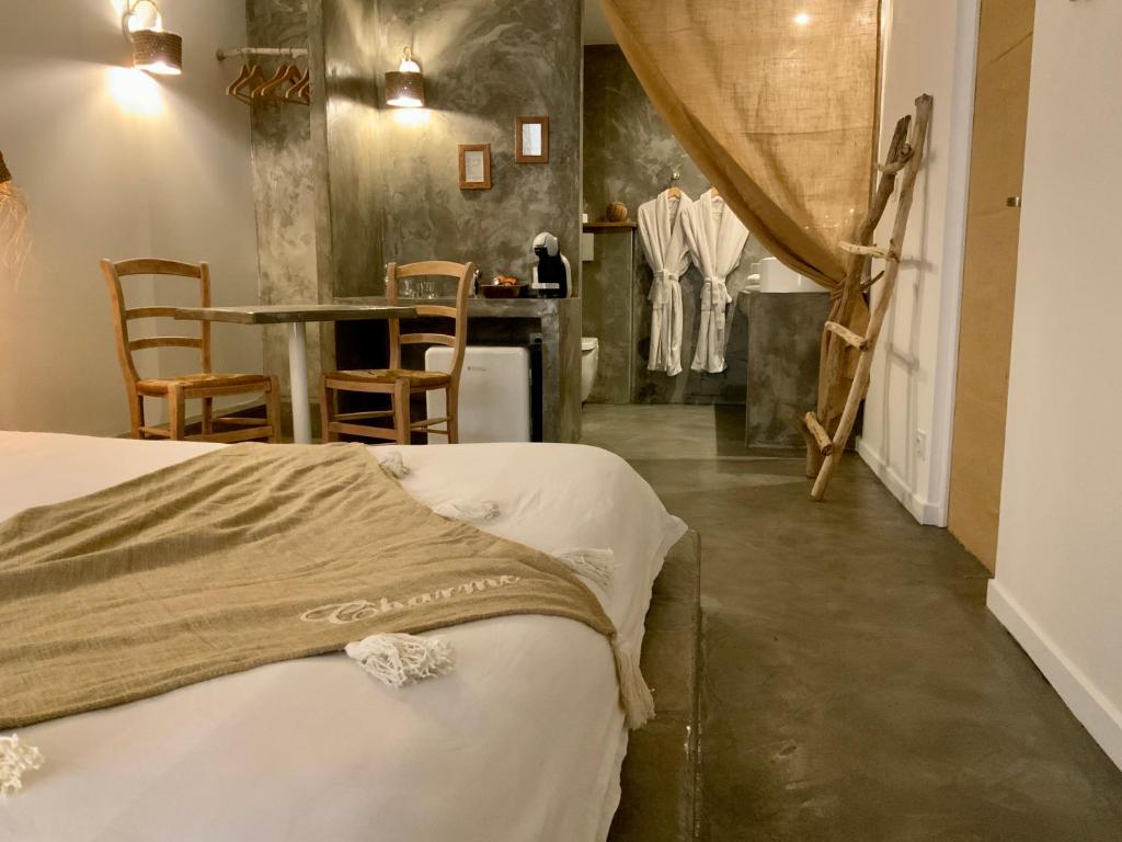 Schlafzimmer mit einem Bett, einem Tisch und Stühlen in der Unterkunft o5sens in Agde