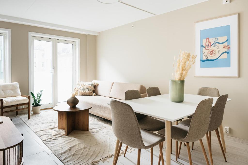 sala de estar con mesa y sofá en Stay Urban - Stylish Scandinavian Gem with French Balcony, en Bergen