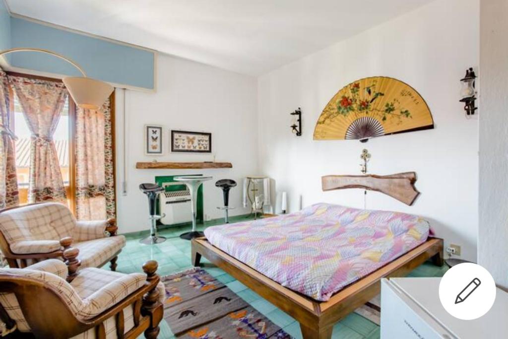 a bedroom with a bed and a chair and a table at Il semaforo Una o due camere matrimoniali con bagno a pochi passi dal centro Pietrasanta, con Wi-Fi in Pietrasanta