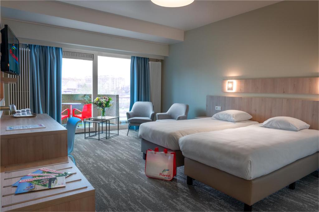 ein Hotelzimmer mit 2 Betten und einem Schreibtisch in der Unterkunft Floreal Blankenberge in Blankenberge