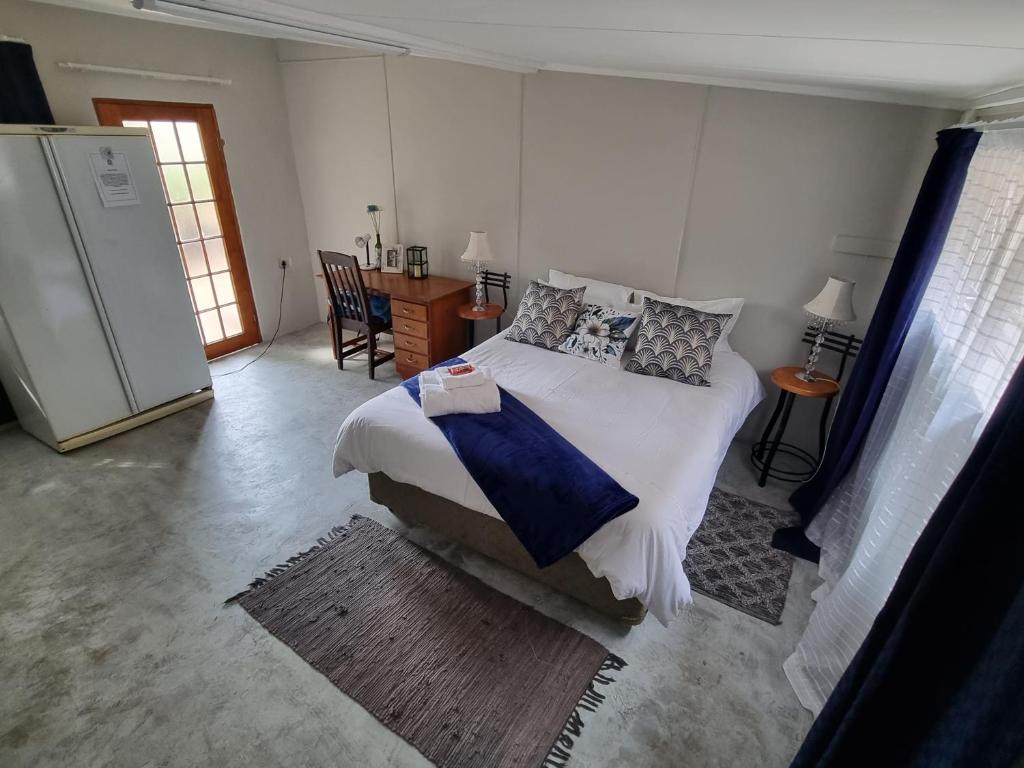 a bedroom with a bed and a table and chairs at Riebeeck Cottage in Potchefstroom