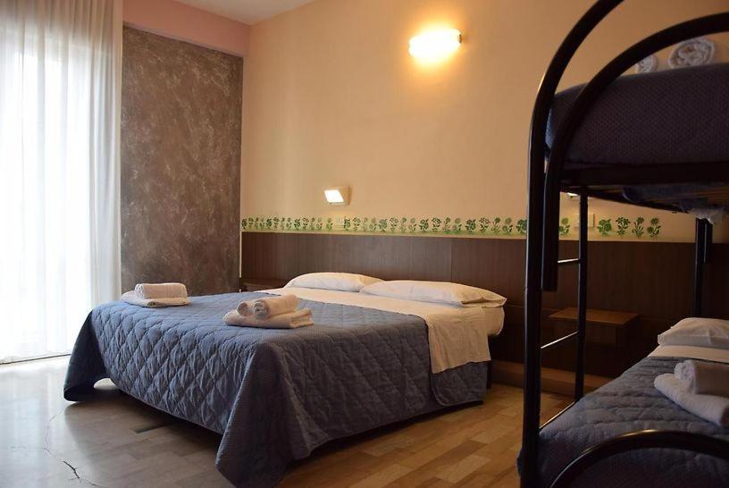 a bedroom with two beds and a bunk bed at Hotel Annetta in Rimini
