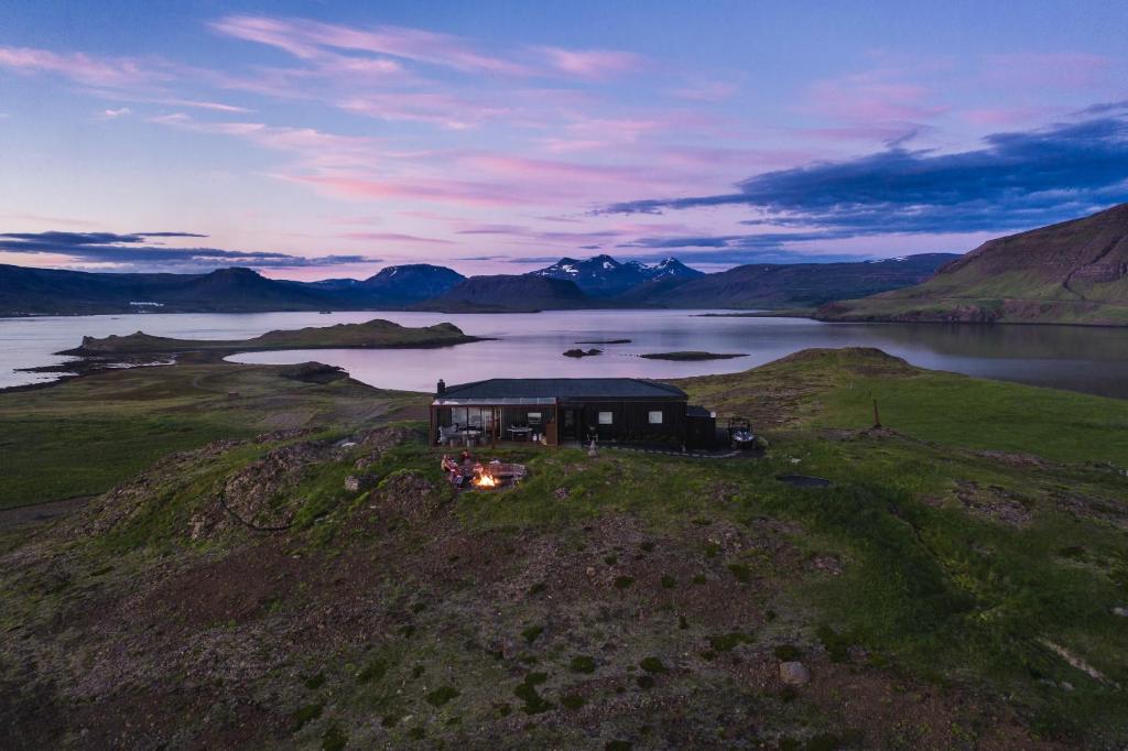 an aerial view of a house on an island in a lake at Hvammsvík Nature Resort in Kjósahreppur