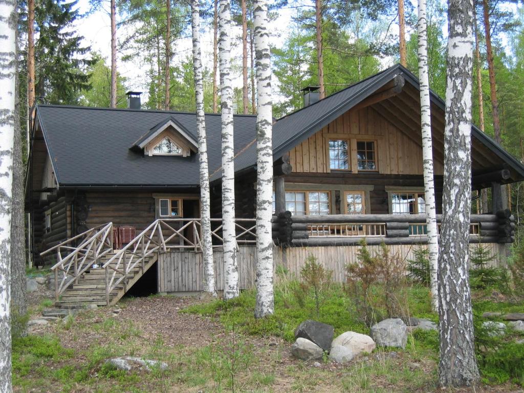 una cabaña de madera en el bosque con árboles en Villa Kaidan Kunkku, en Ristiina