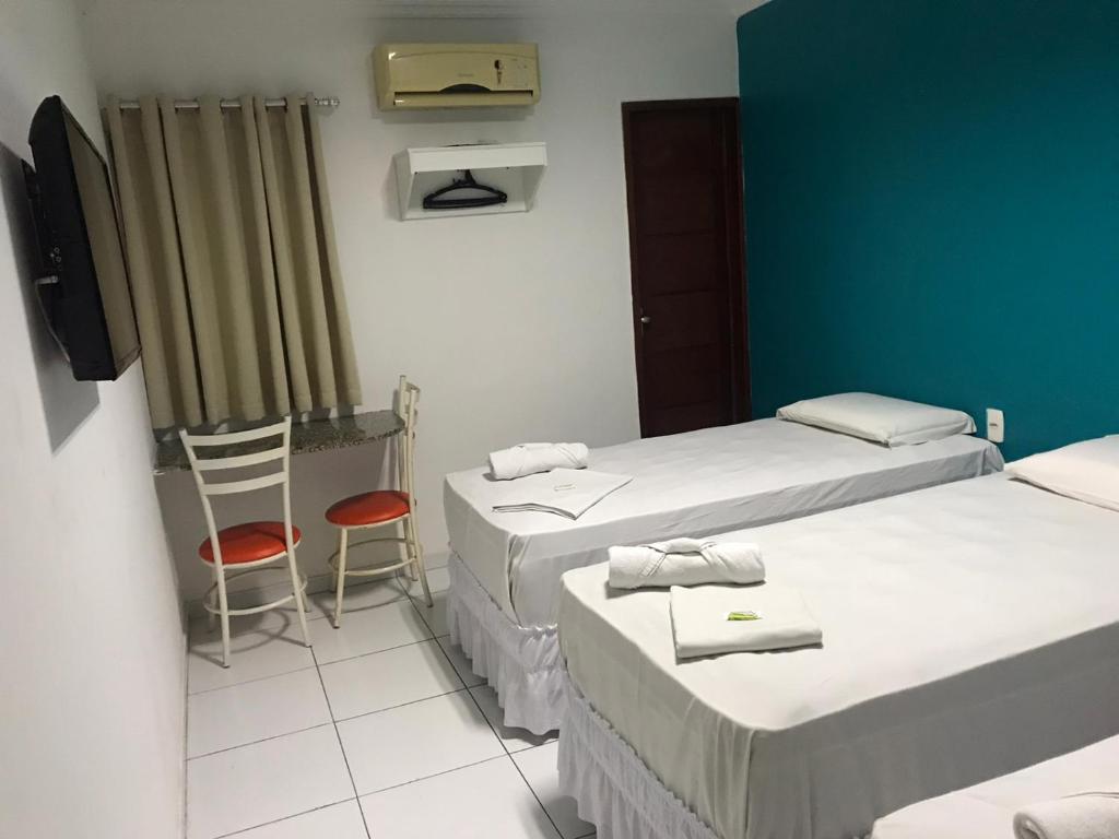 a hospital room with two beds and a chair at Lax Hotel acesso através de escadas in Campina Grande