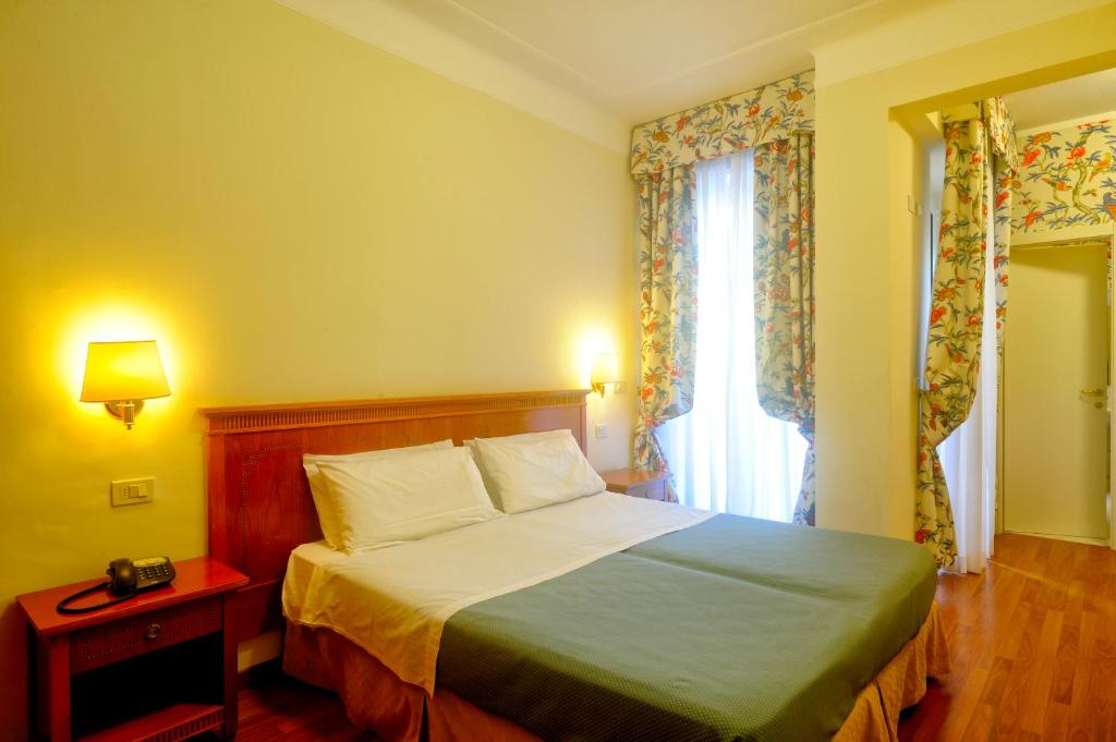 1 dormitorio con cama y ventana en Hotel Majestic, en Alassio