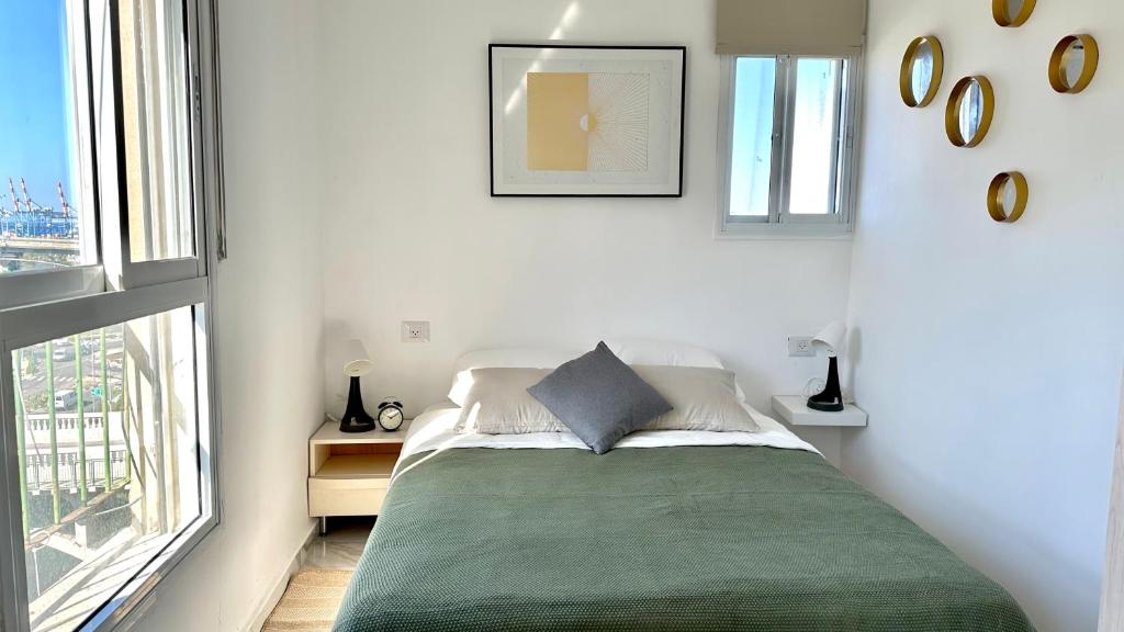 ein Schlafzimmer mit einem Bett mit einer grünen Decke in der Unterkunft Cozy one bedroom Limeapartment in Haifa