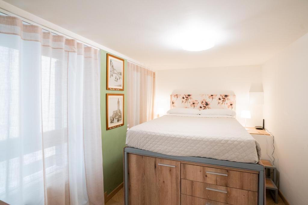 Un dormitorio pequeño con una cama y una ventana. en Domus Verona - Borsari Pied-à-terre, en Verona
