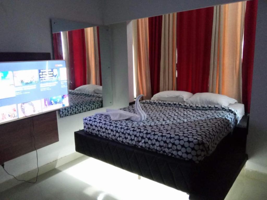 a bedroom with a mirror and a bed and a tv at Hotel Arcane in Cox's Bazar