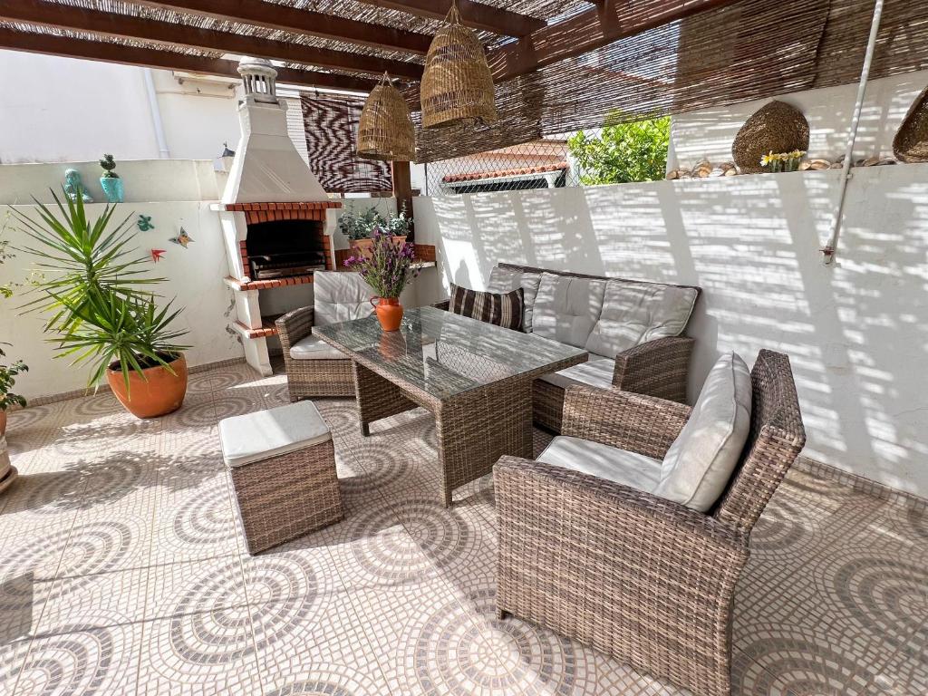 a patio with a table and chairs and a fireplace at Casa Miobelle - Tavira in Tavira