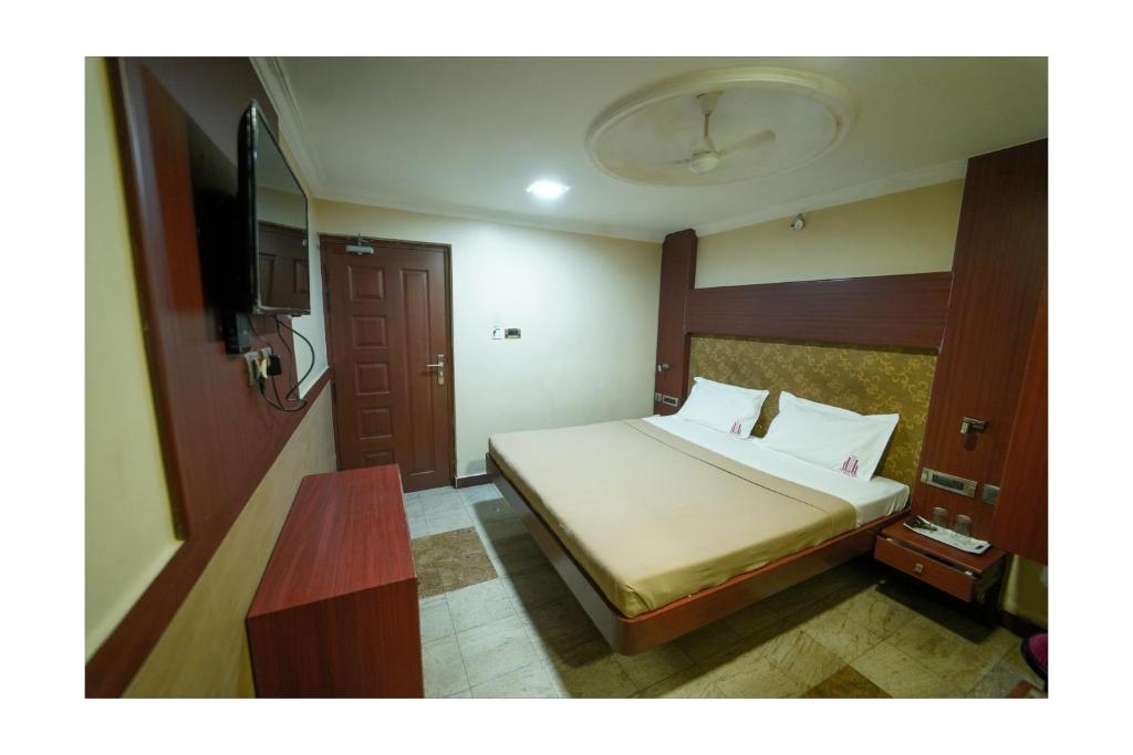 a bedroom with a bed and a table in it at EVEREST PARK RESIDENCY in Tiruchchirāppalli