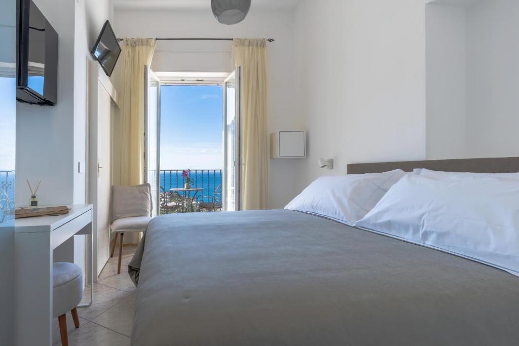 a bedroom with a bed and a view of the ocean at Albergo La Prora in Capri