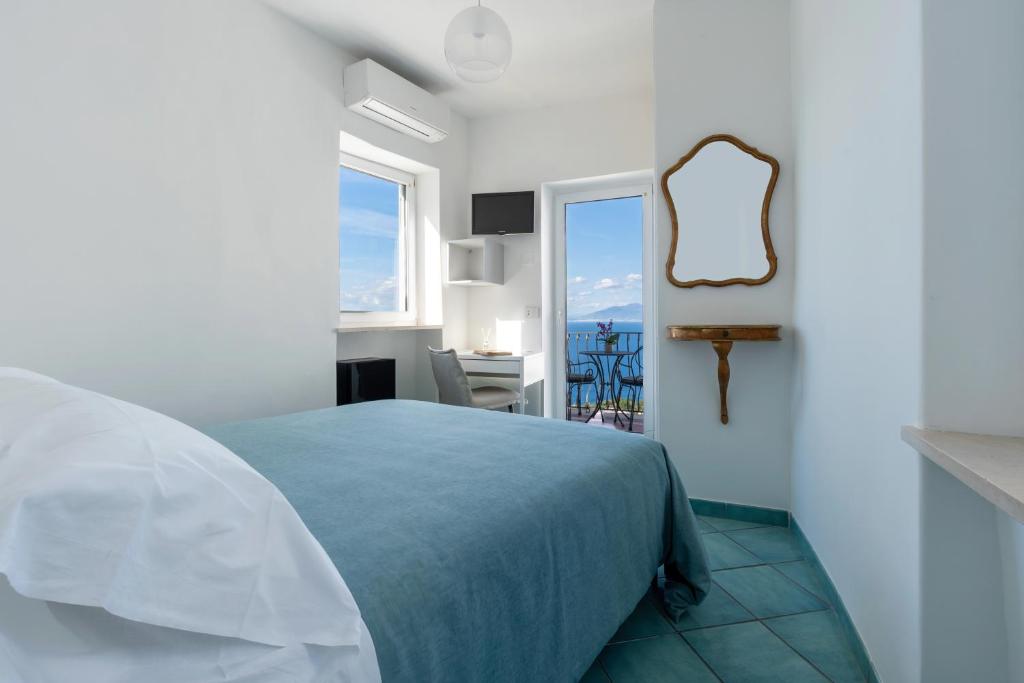 a bedroom with a bed and a view of the ocean at Albergo La Prora in Capri