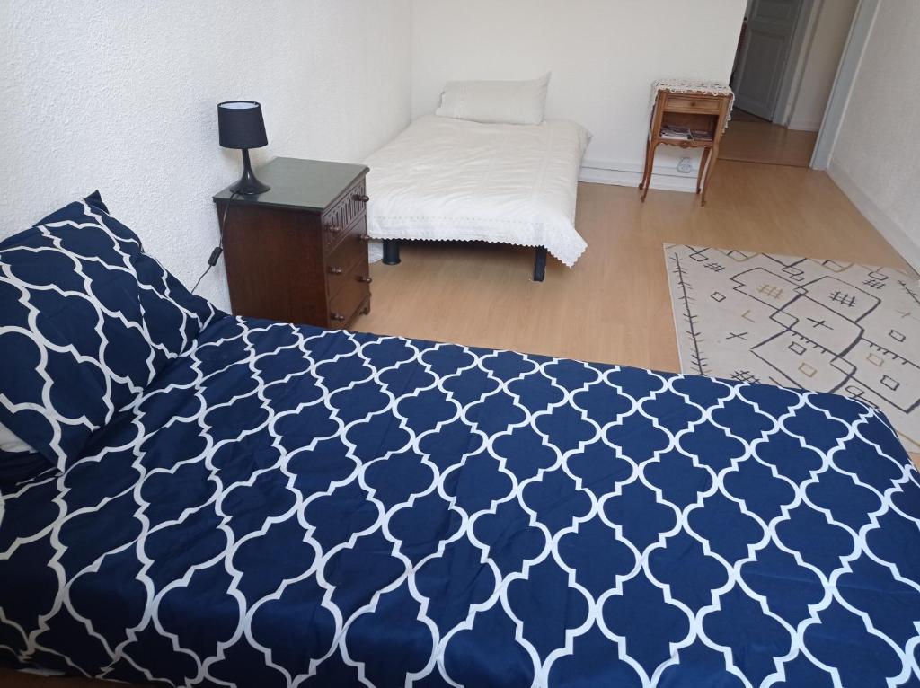 een slaapkamer met een bed met een blauw en wit dekbed bij antoinette in Carcassonne