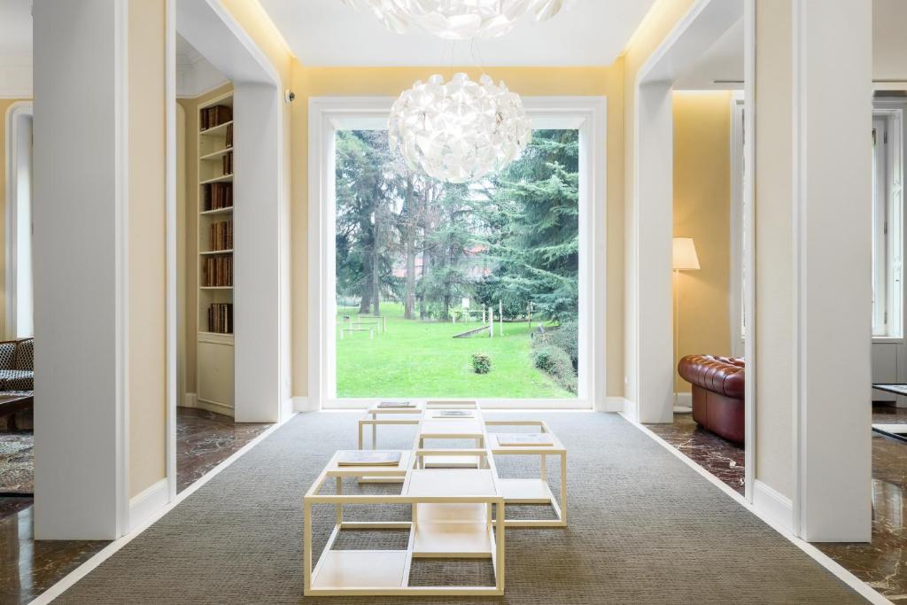 uma sala de estar com um lustre e mesas em Hotel Tiziano - Gruppo Mini Hotel em Milão