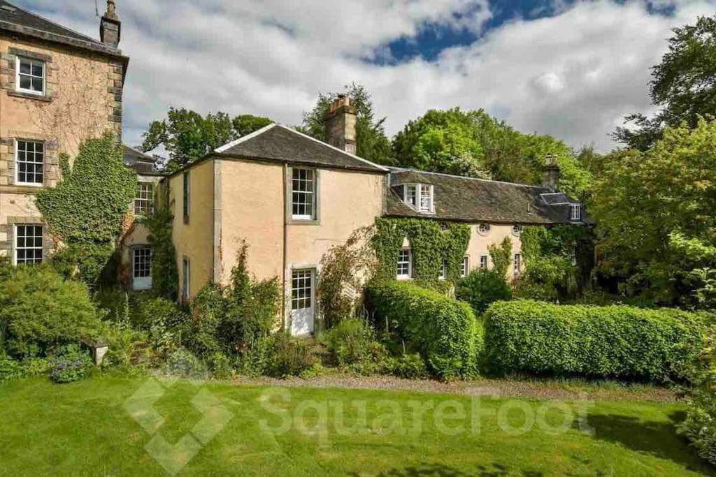 une maison ancienne avec un jardin en face dans l'établissement Powis House Mid Cottage, à Stirling