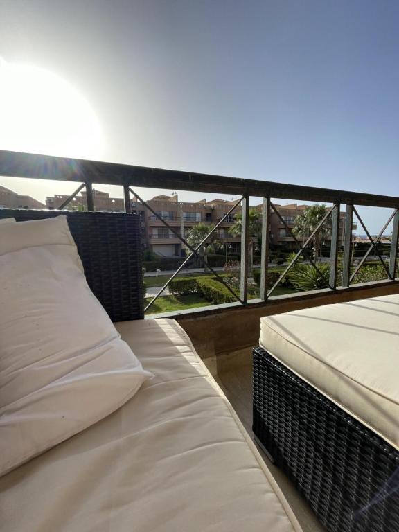 two beds on a balcony with a view of a city at 396 Blumar Chalet North Coast Sidi-abdelrahman families & couples only in El Alamein