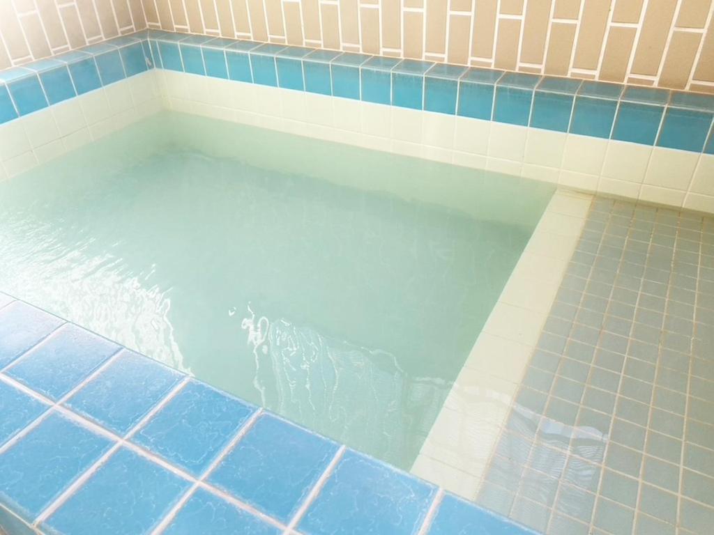 a pool of water in a bathroom with blue tiles at Yufu - House - Vacation STAY 89885 in Yufuin