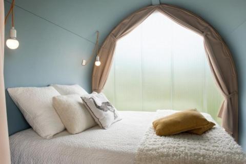 een slaapkamer met een bed en een groot raam bij Camping la Chaumière in Heimsbrunn
