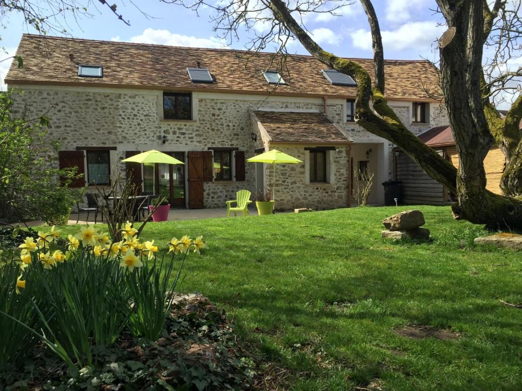 una casa con un patio con sombrillas amarillas en Escalebelair, en Fontenay-lès-Briis