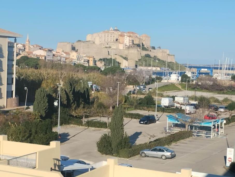 - une vue sur un parking avec une colline en arrière-plan dans l'établissement Calvi duplex climatisé vue mer 4 pers, à Calvi