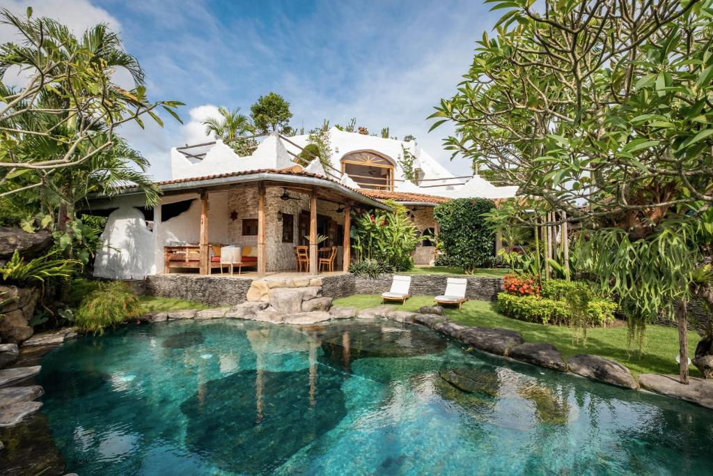 a house with a swimming pool in front of a house at Casa Mila - 4BR Luxury Villa 5 Min from Canggu Beach in Canggu