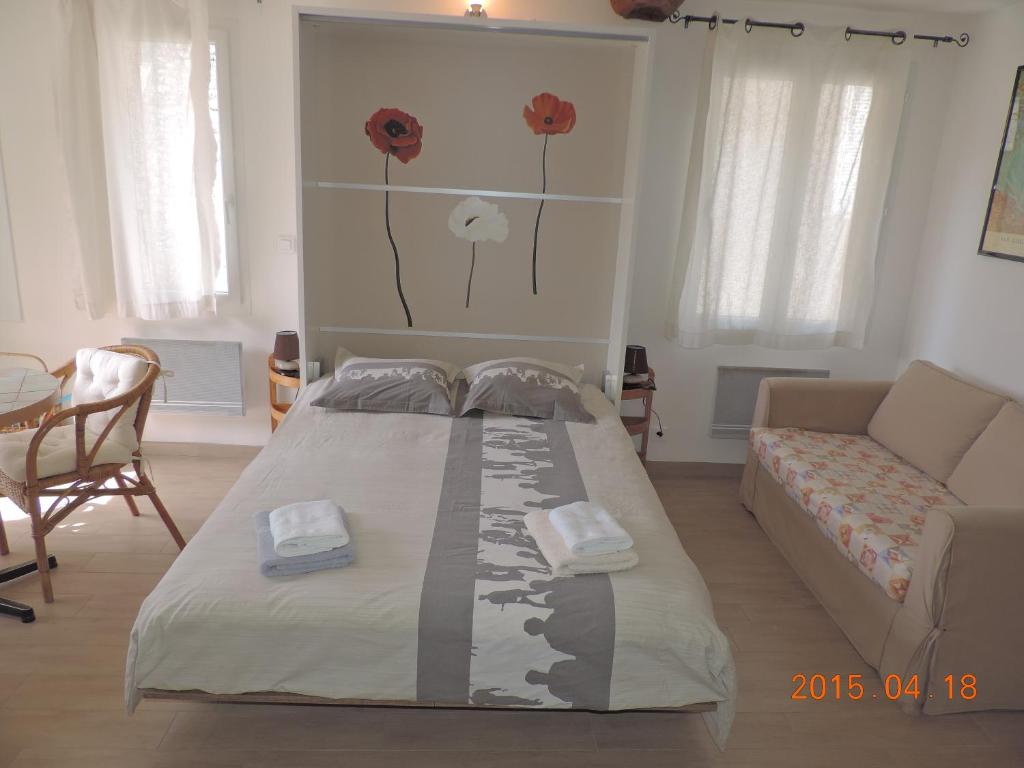 a bedroom with a large bed and a couch at Les Cigales d'Estoublon in Estoublon