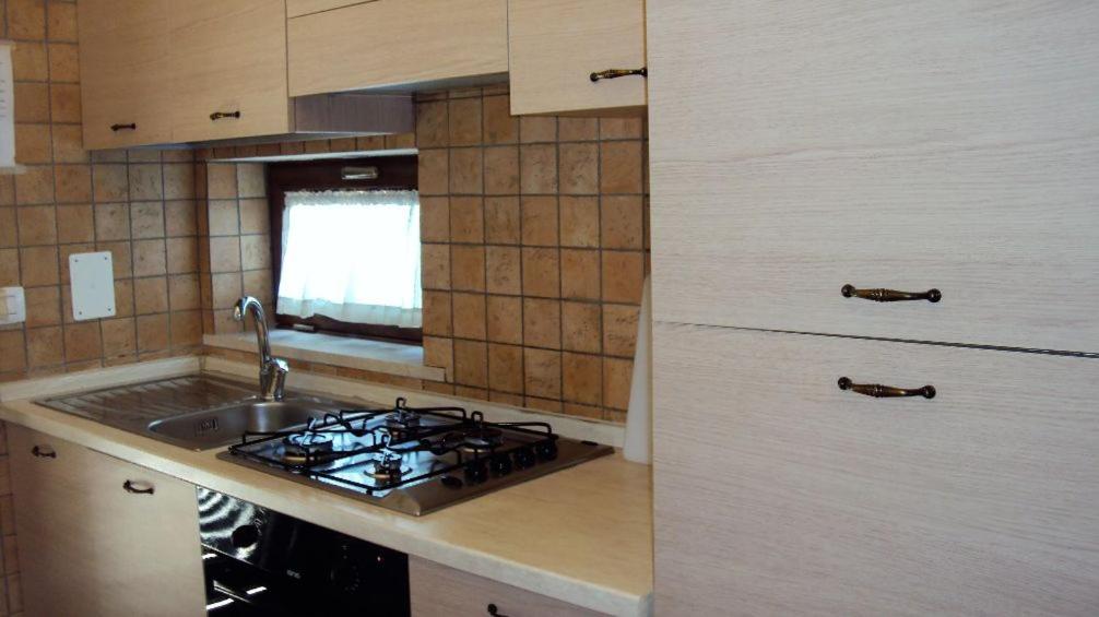 cocina con fregadero y fogones horno superior en Casale in villa tipica Salentina con Piscina, en Copertino
