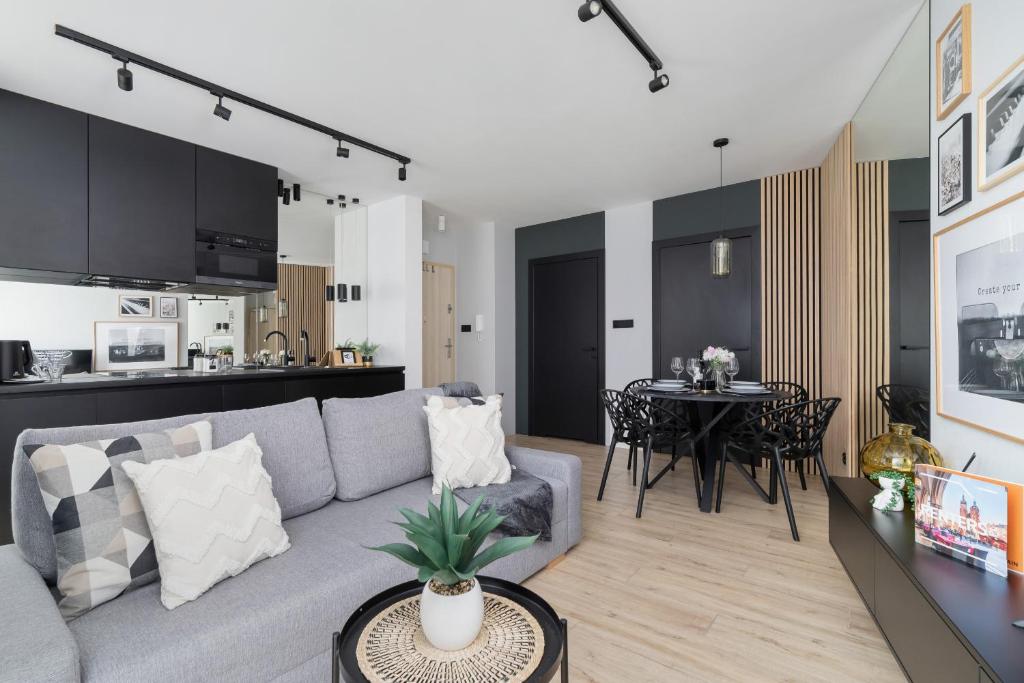 a living room with a gray couch and a table at Deluxe City Studio Kącik 10 by Renters in Krakow
