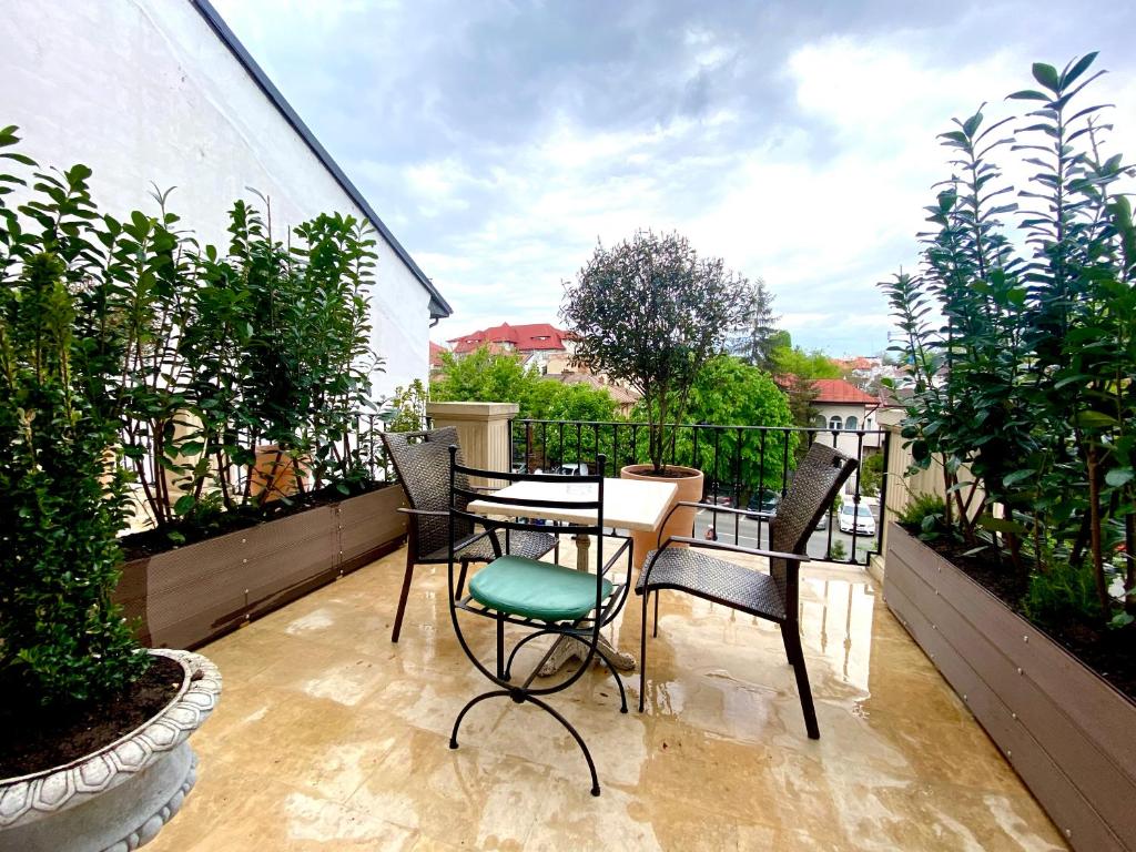 a patio with a table and chairs on a balcony at Arc de Triomphe Studios in Bucharest