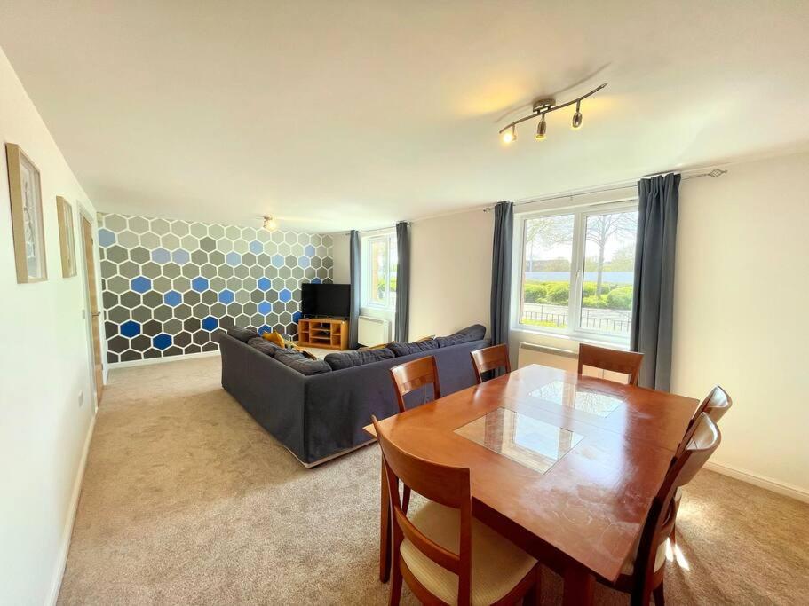 ein Wohnzimmer mit einem Tisch und einem Sofa in der Unterkunft Spacious 3-Bedroom Ground Floor Flat with Free Parking in Central Location in Cardiff