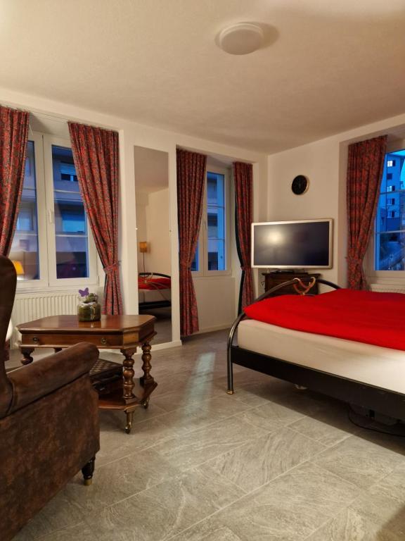 a bedroom with a bed and a couch and windows at Bastis Luxury Studios - Free Parking in Lucerne