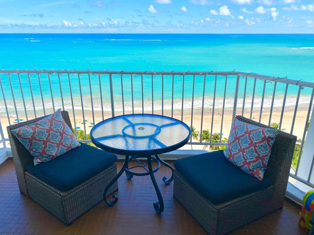 a balcony with a table and two chairs and the beach at Marbella del Caribe Isla Verde Beachfront in San Juan