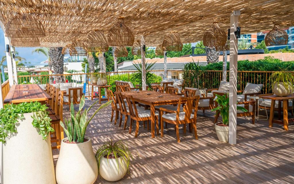 an outdoor patio with tables and chairs and plants at Liberty Hotels Lara in Lara