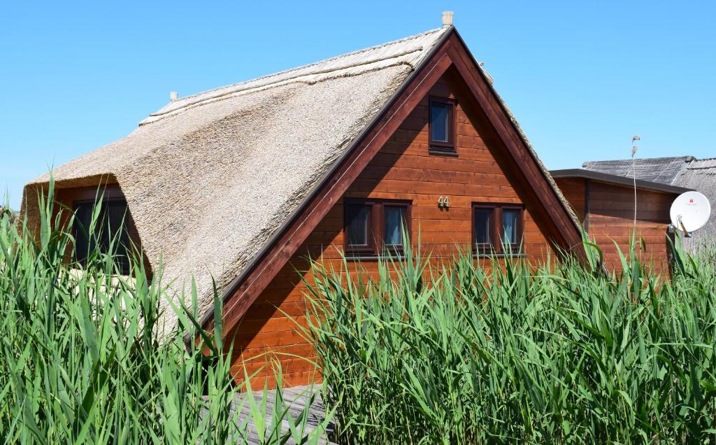 a wooden house with a thatched roof at Chalet im See- Nr 44 in Rust