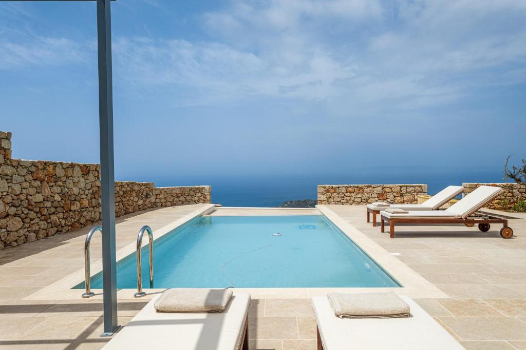 a swimming pool with a view of the ocean at Patio Villas Complex in Stoupa