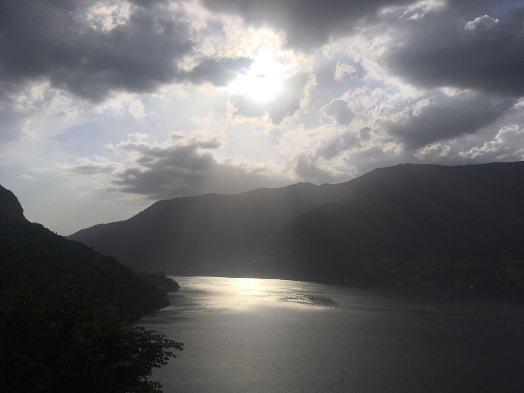 - une vue sur la rivière et le soleil dans le ciel dans l'établissement Top Lake View, à Faggeto Lario 