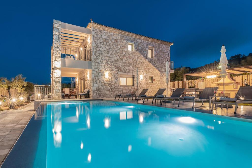 une grande piscine en face d'une maison dans l'établissement Claudio Stone House, à Vasilikos